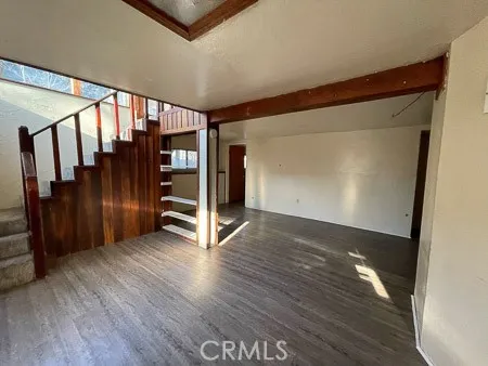 a view of a hallway with wooden floor and stairs