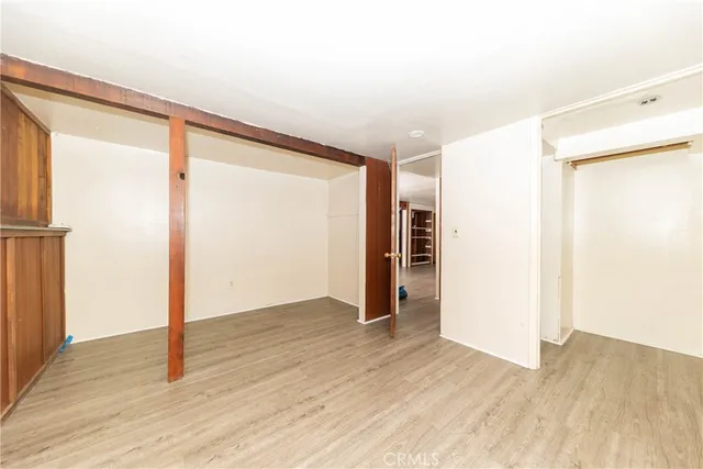 an empty room with wooden floor and a window