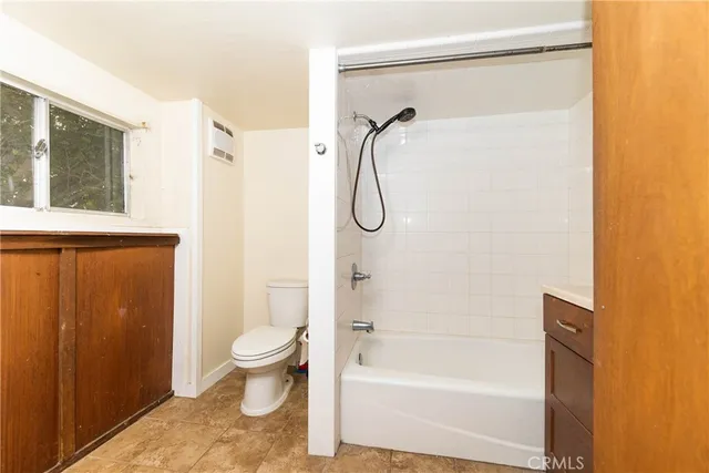 a bathroom with a granite countertop shower toilet and sink