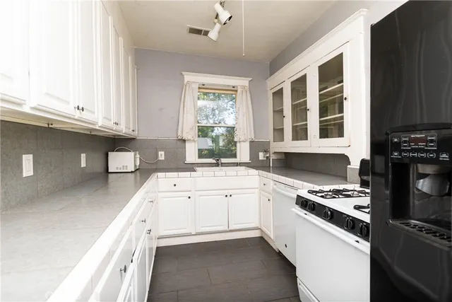 a kitchen with granite countertop a sink a stove and cabinets