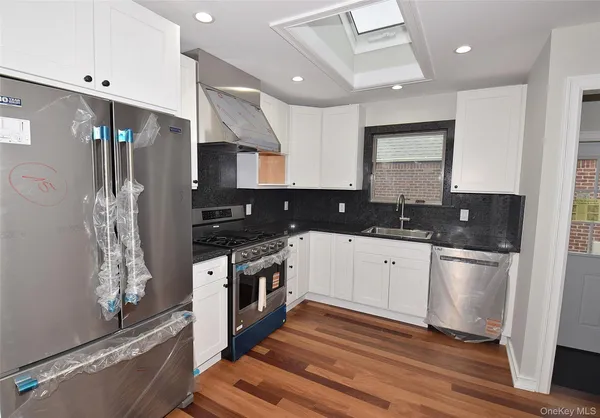 a kitchen with stainless steel appliances granite countertop a stove a sink and a refrigerator