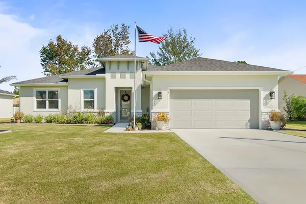 a front view of a house with a yard and garage