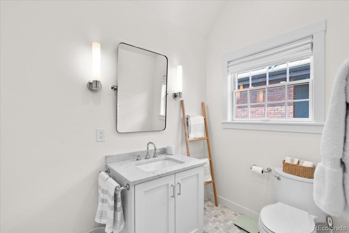 535 Garfield Street Denver, CO 80206 - Photo 43 of 50 a bathroom with a granite countertop sink toilet and shower