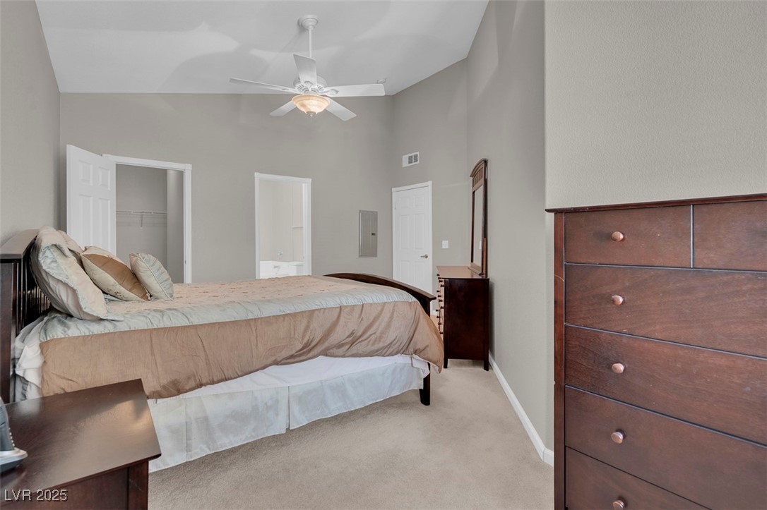 10550 West Alexander Road, Unit 2064 Las Vegas, NV 89129 - Photo 22 of 51 Bedroom with visible vents, a closet, electric panel, a spacious closet, and light carpet