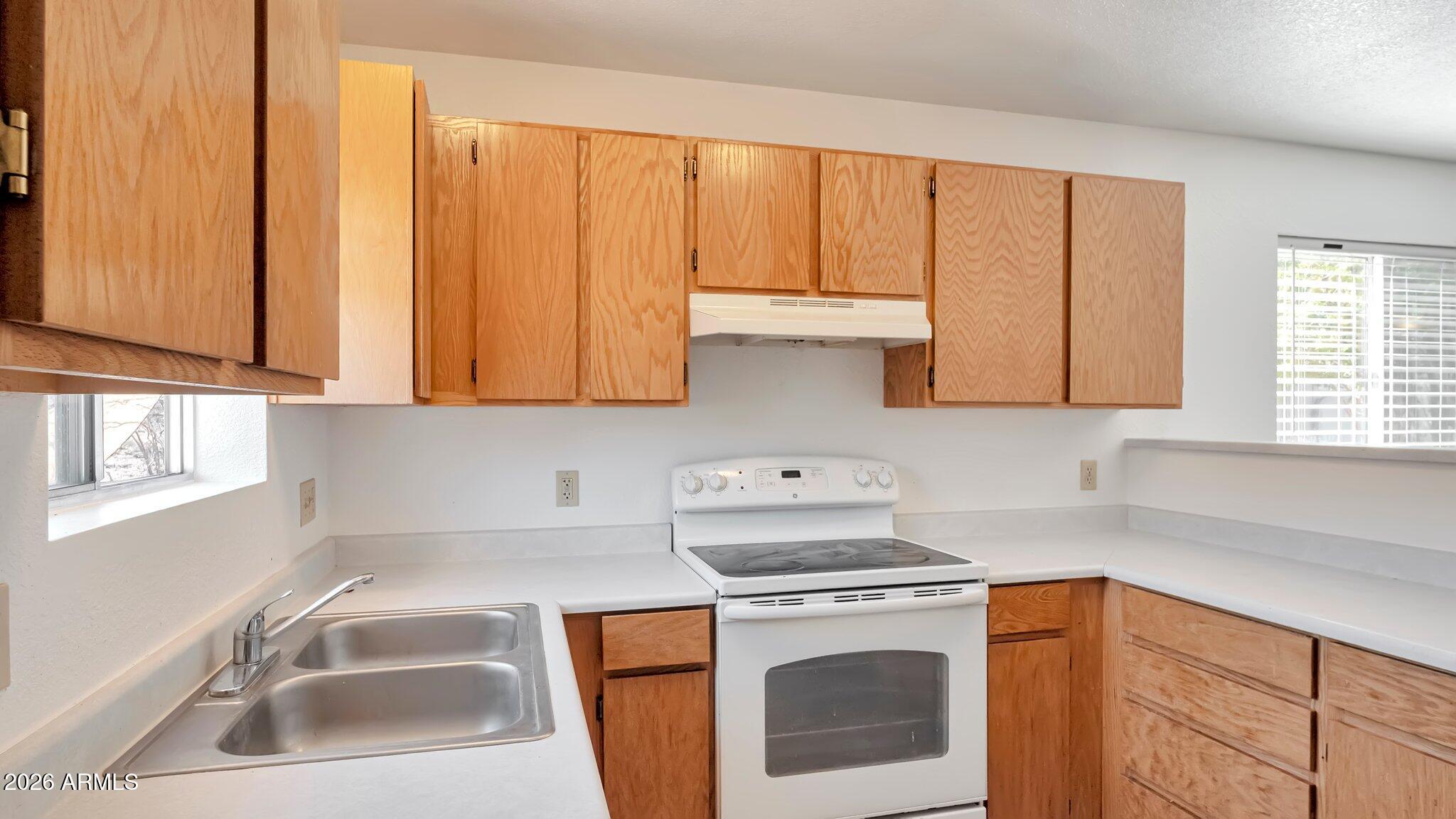 4125 North Pima Way Rimrock, AZ 86335 - Photo 2 of 14 a kitchen with stainless steel appliances granite countertop a sink a stove and white cabinets
