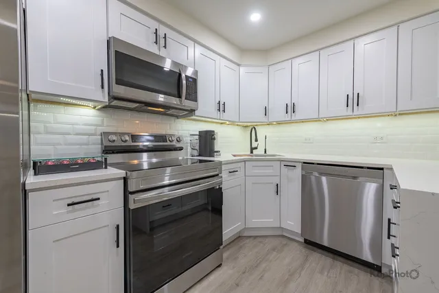 a kitchen with cabinets stainless steel appliances and wooden floor