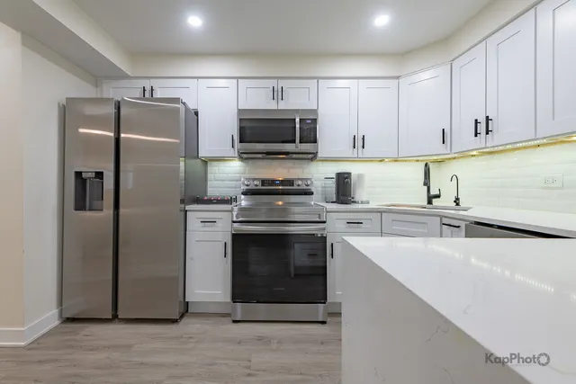 a kitchen with a sink stainless steel appliances and cabinets