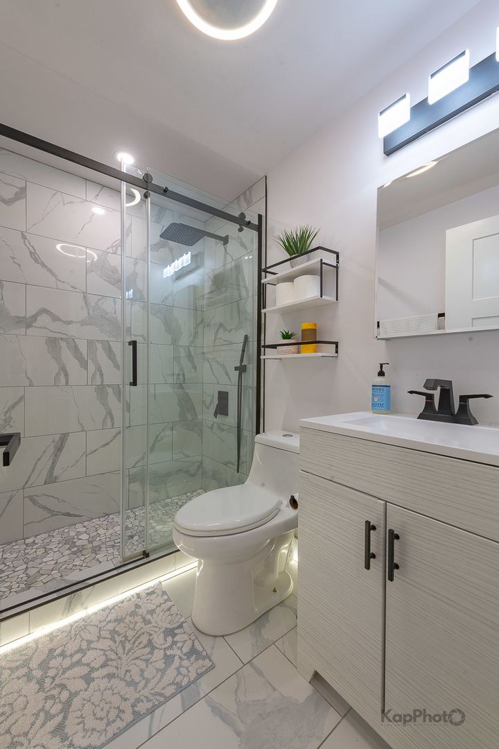 6612 West 64th Place, Unit 2W Chicago, IL 60638 - Photo 23 of 28 a bathroom with a shower toilet and sink