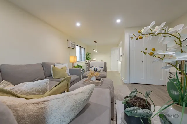 a living room with furniture flowerpot and a chandelier
