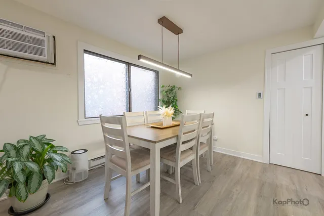 a dining room with furniture potted plants and wooden floor