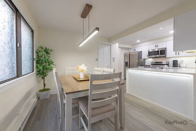 a kitchen with kitchen island a table and chairs in it