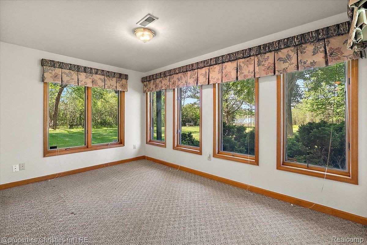 6175 Tripp Road Holly, MI 48442 - Photo 29 of 63 Room featuring multiple wood-framed windows, carpeted flooring, and white walls