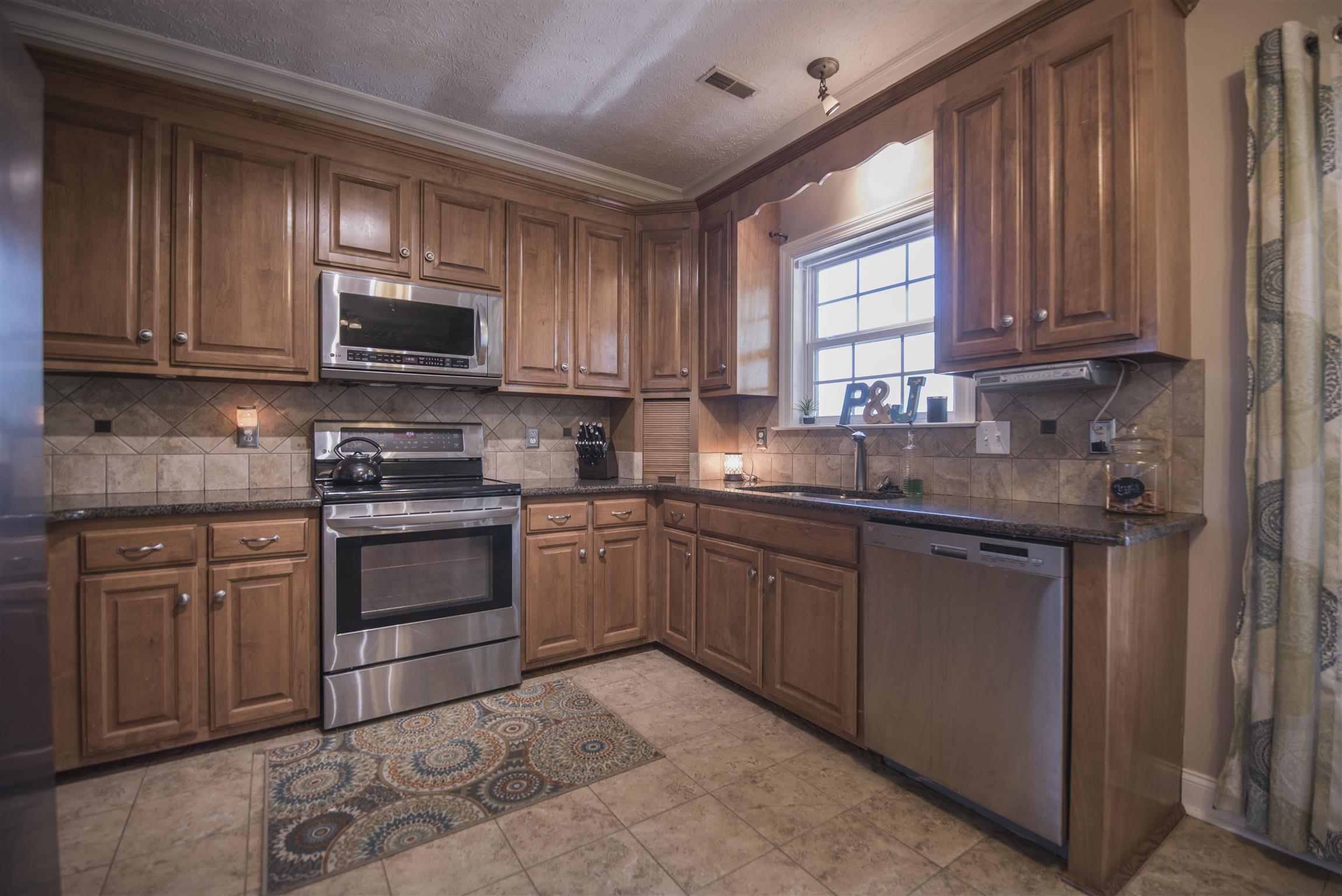 14904 Mt Pleasant Road Rockvale, TN 37153 - Photo 8 of 23 a kitchen with stainless steel appliances granite countertop a stove sink microwave and window