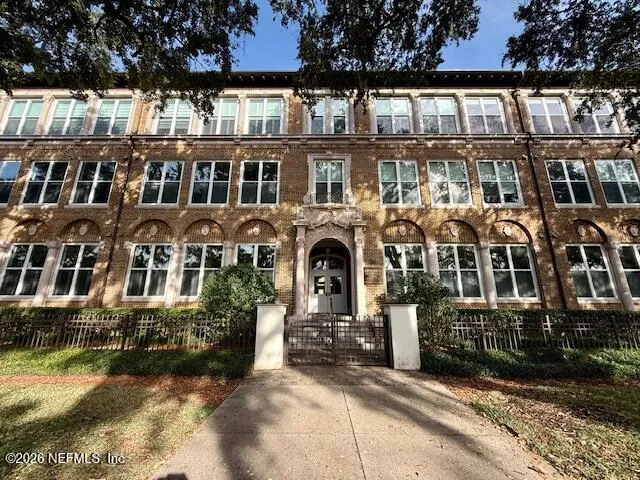front view of a brick house with a small yard