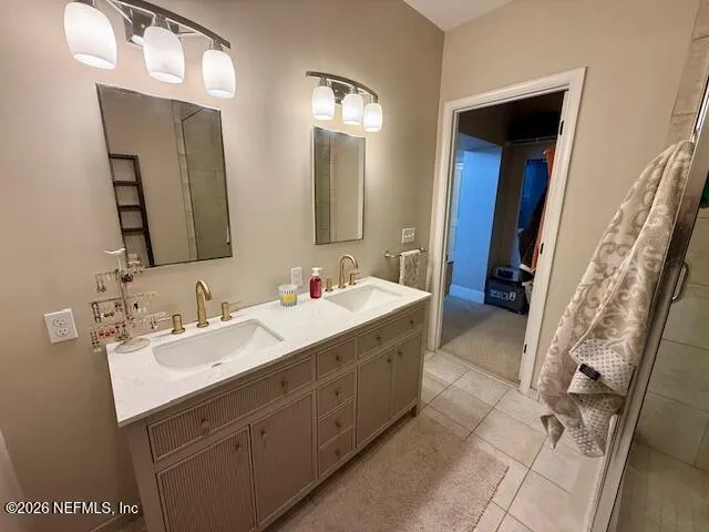 a bathroom with a double vanity sink mirror and shower