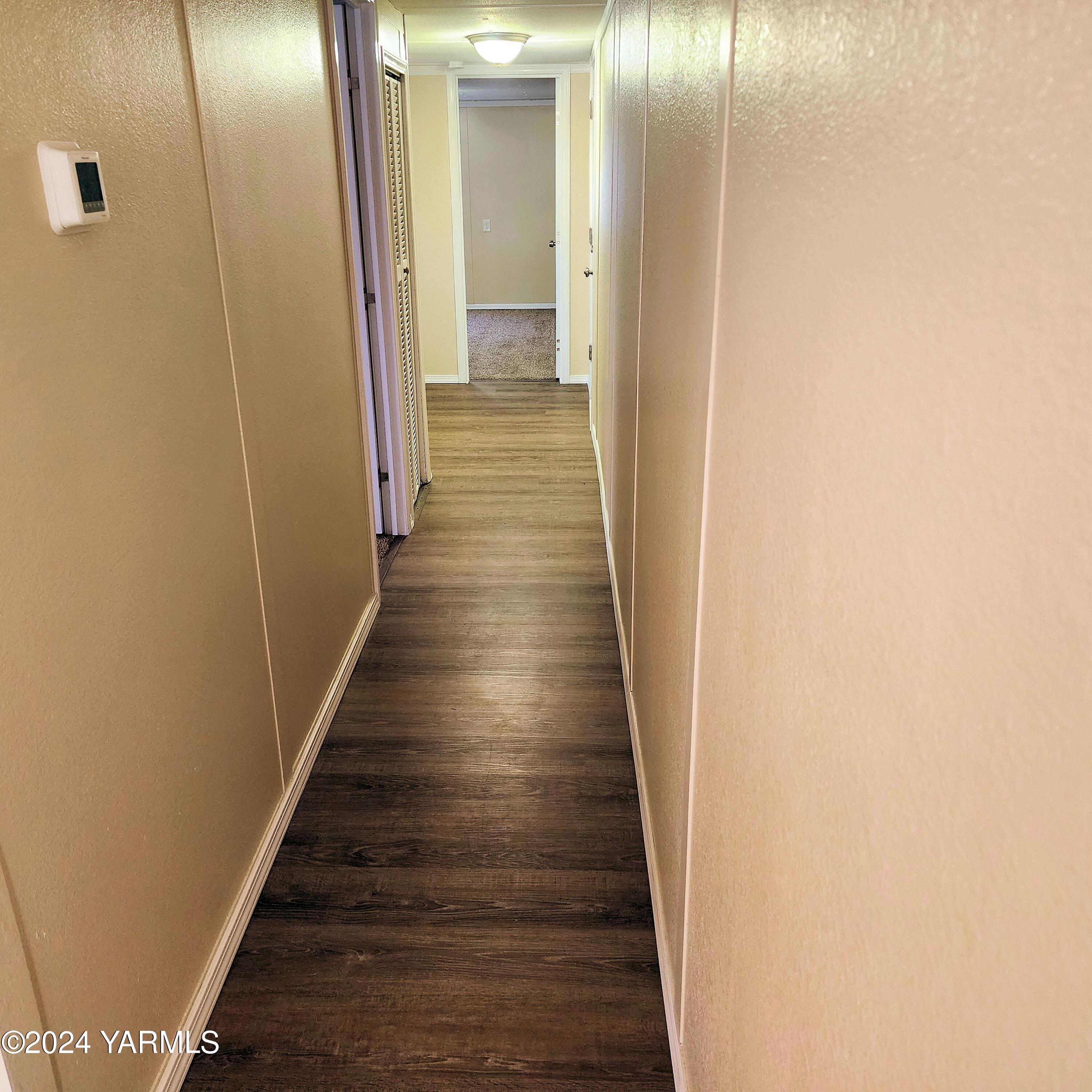 181 Schut Road, Unit 34 Moxee, WA 98936 - Photo 15 of 18 a view of a hallway with wooden floor