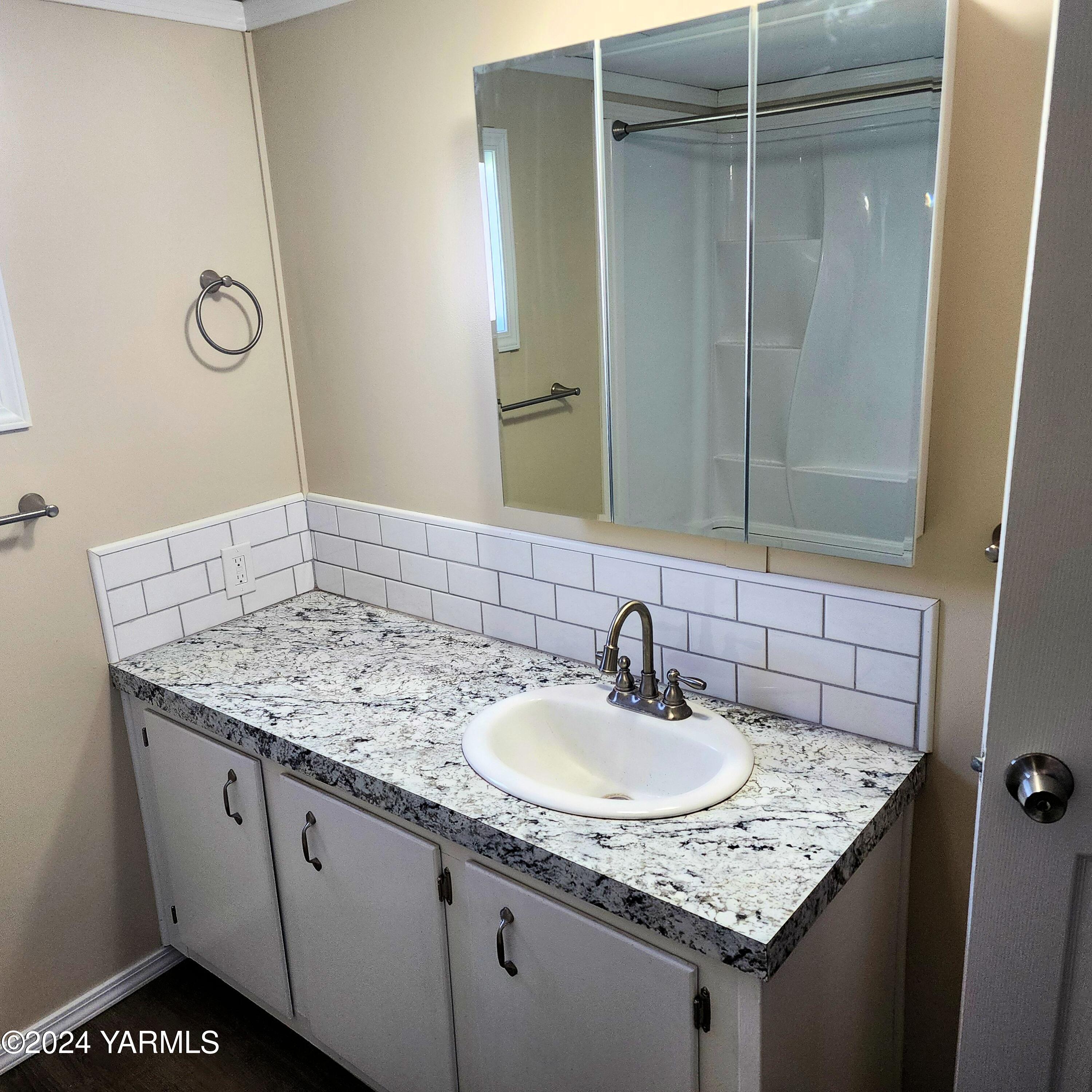 181 Schut Road, Unit 34 Moxee, WA 98936 - Photo 17 of 18 a bathroom with a granite countertop sink and a mirror