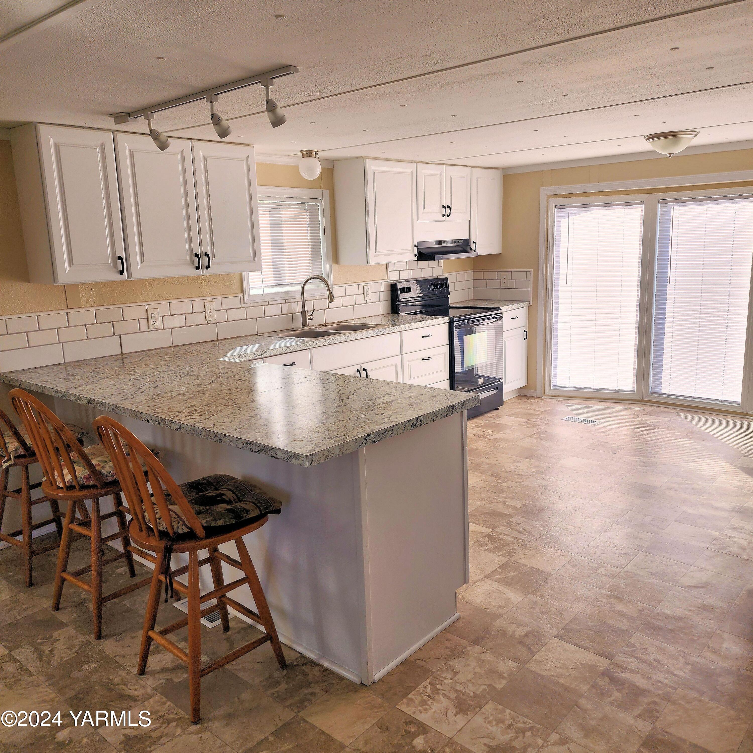 181 Schut Road, Unit 34 Moxee, WA 98936 - Photo 7 of 18 a kitchen with stainless steel appliances granite countertop a stove a sink and a granite counter tops