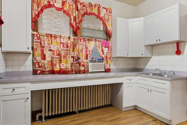 a kitchen with stainless steel appliances granite countertop a sink and cabinets with wooden floor