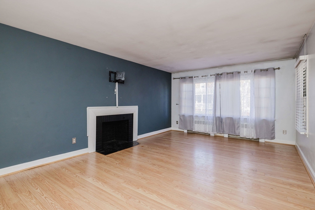 277 Valentine Street Fall River, MA 02720 - Photo 18 of 34 a view of empty room with wooden floor and fireplace
