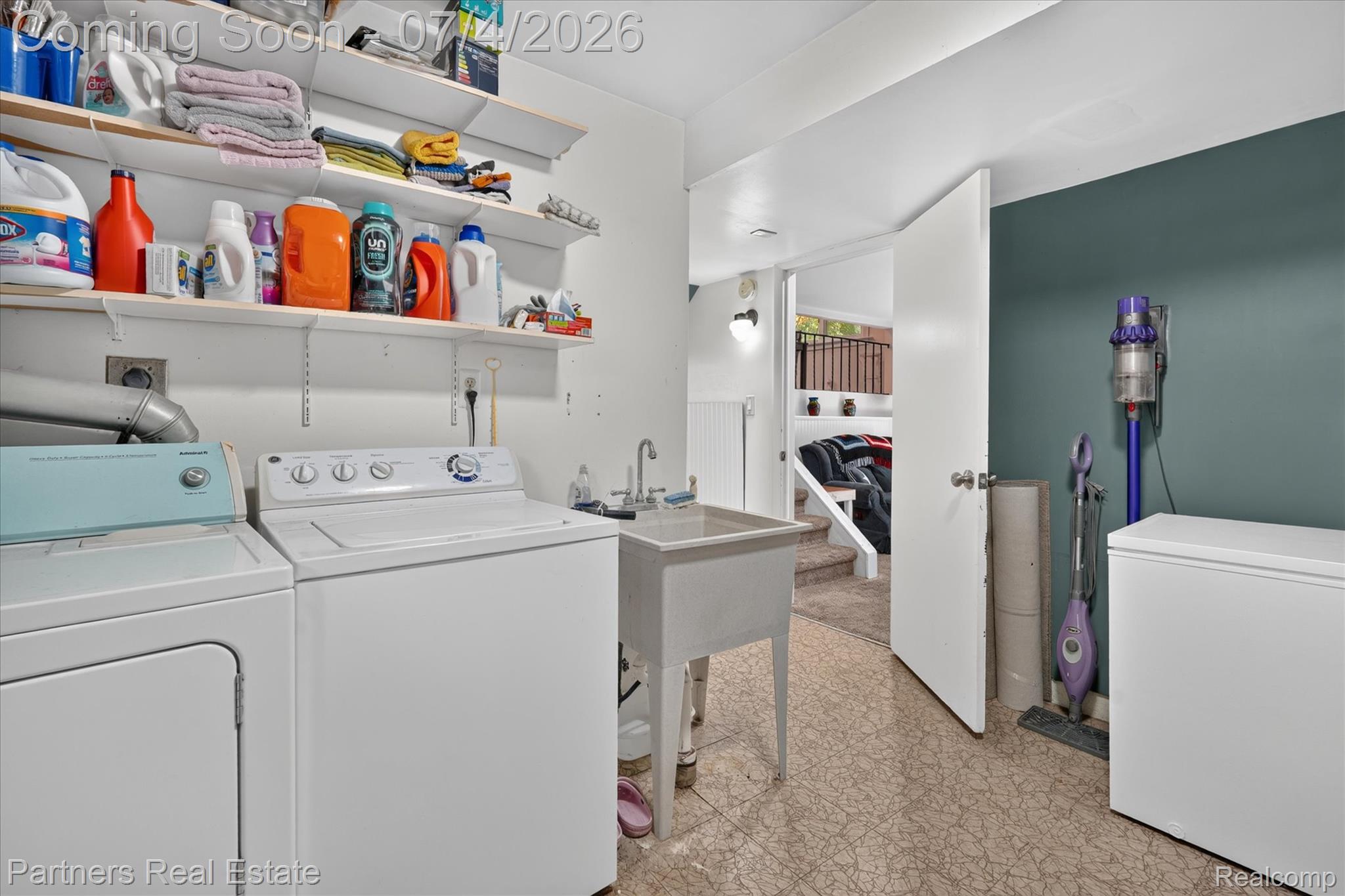 2500 Hubert Road Brighton, MI 48114 - Photo 36 of 53 Dedicated laundry area featuring a utility sink, open shelving, and patterned flooring