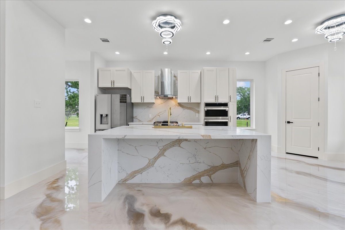 3237 Harkey Road Pearland, TX 77584 - Photo 11 of 46 Chef’s kitchen with oversized waterfall island and custom cabinetry.