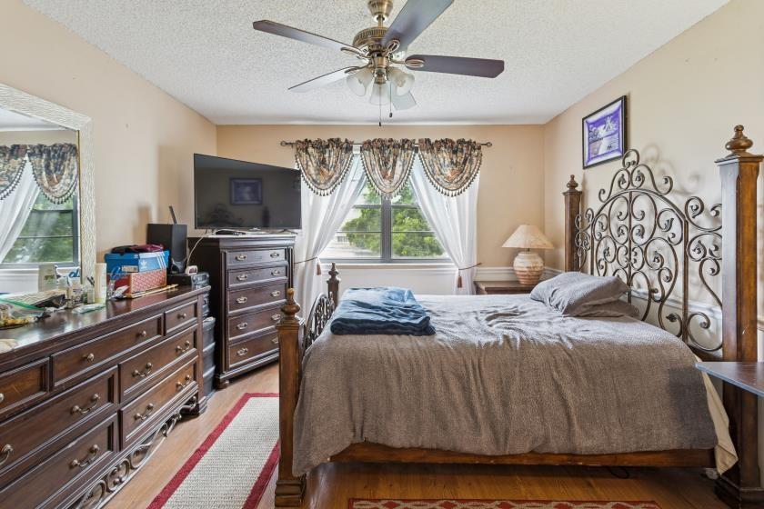 9670 West McNab Road, Unit 208 Tamarac, FL 33321 - Photo 13 of 22 a bedroom with a bed and a flat screen tv