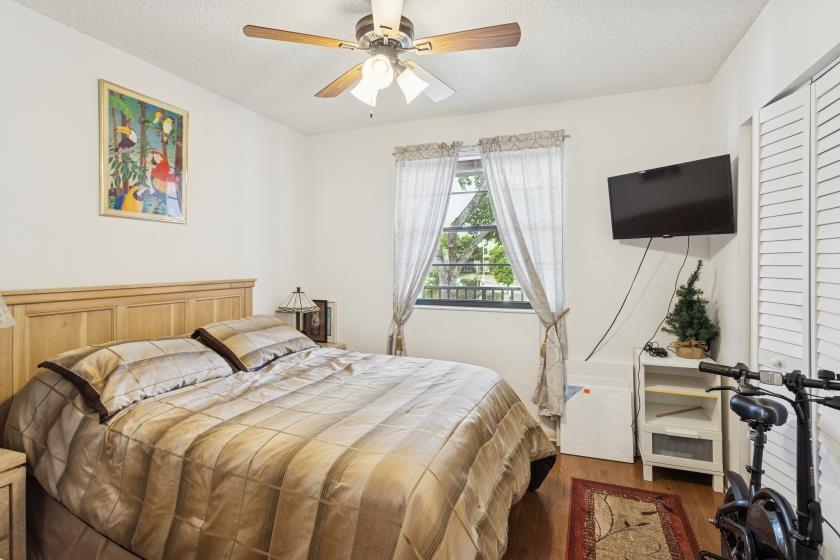 9670 West McNab Road, Unit 208 Tamarac, FL 33321 - Photo 16 of 22 a bedroom with a bed and a flat screen tv