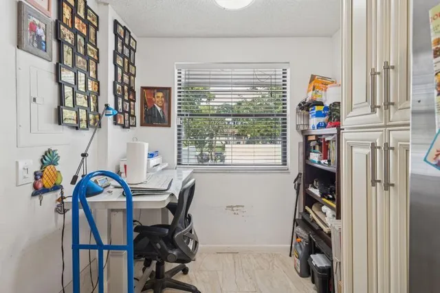 a view of a workspace with furniture and a window