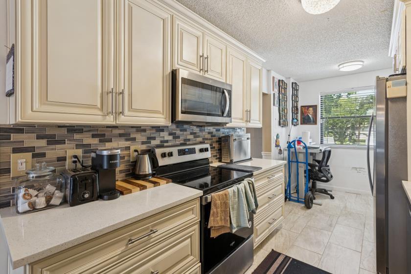 9670 West McNab Road, Unit 208 Tamarac, FL 33321 - Photo 9 of 22 a kitchen with a stove and a refrigerator