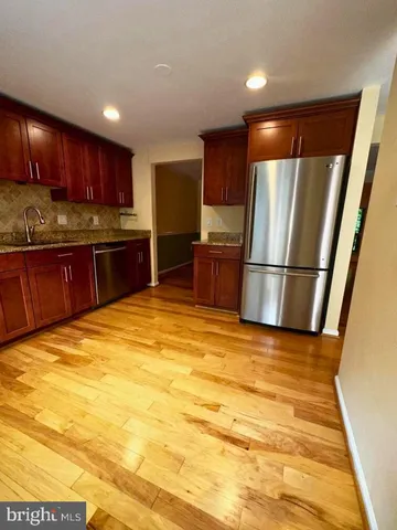 a kitchen with stainless steel appliances granite countertop a refrigerator sink and cabinets