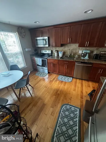a kitchen with granite countertop a stove a sink and a microwave