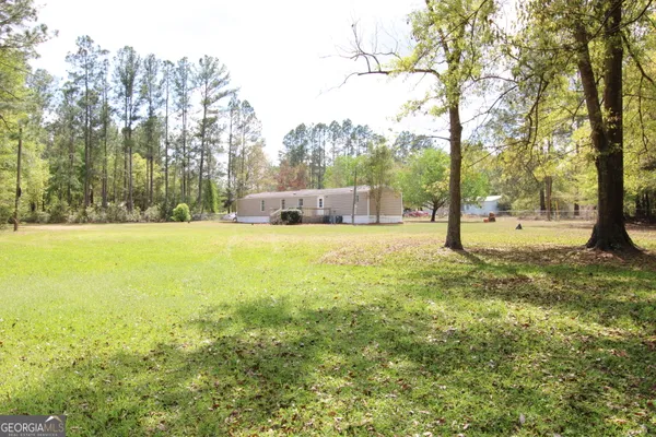 a view of a yard with a house and large trees