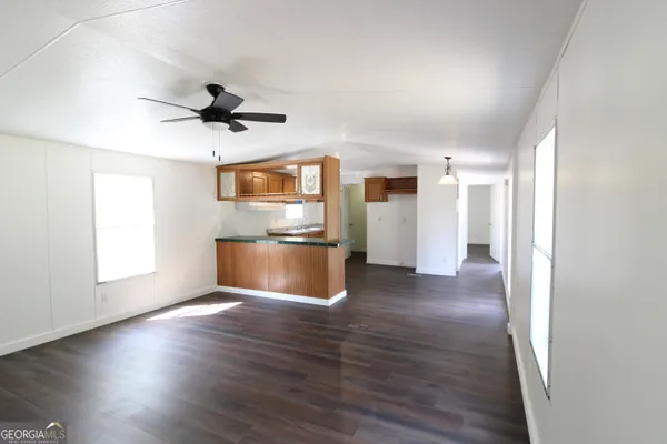 a view of empty room with wooden floor and window