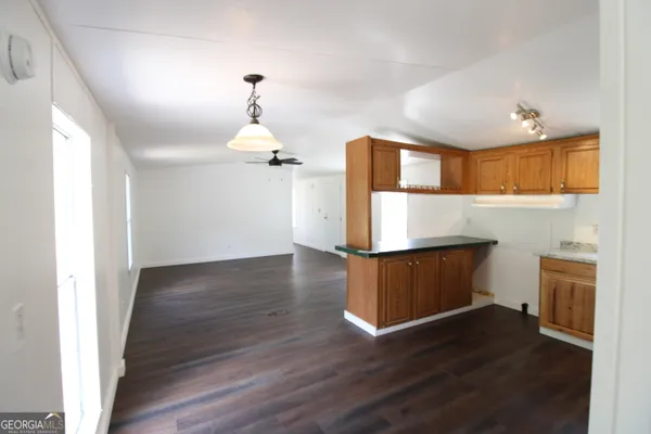 a kitchen with a wooden floor and a refrigerator