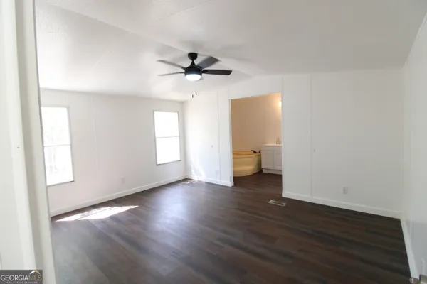 a view of a room with wooden floor and ceiling fan