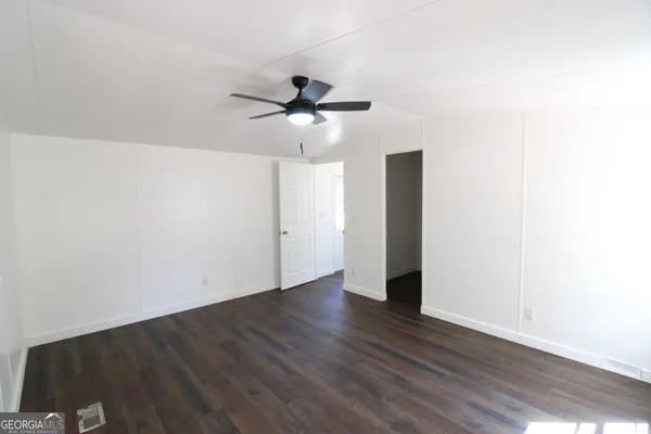 a view of an empty room with wooden floor
