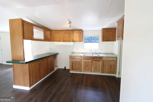 a view of a kitchen with a sink wooden floor and a cabinet