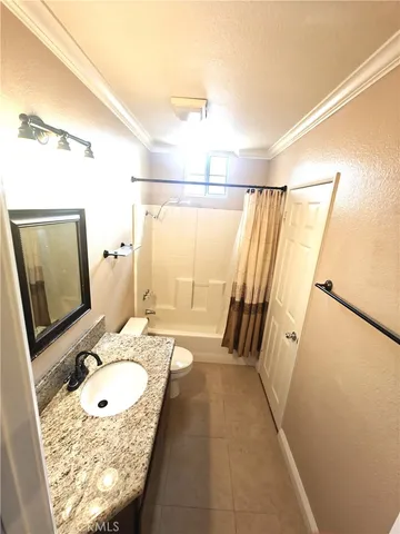 a bathroom with a granite countertop sink mirror vanity and a shower