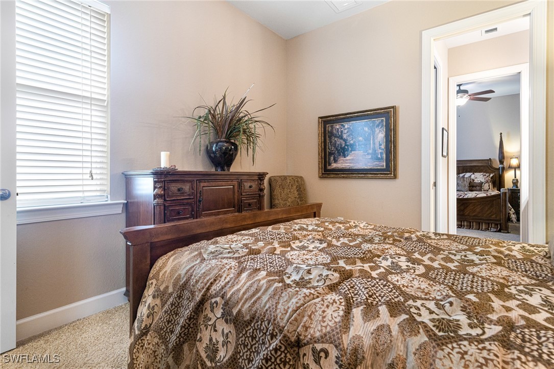 11208 Lithgow Lane Fort Myers, FL 33913 - Photo 23 of 49 a bedroom with a large bed and a chandelier