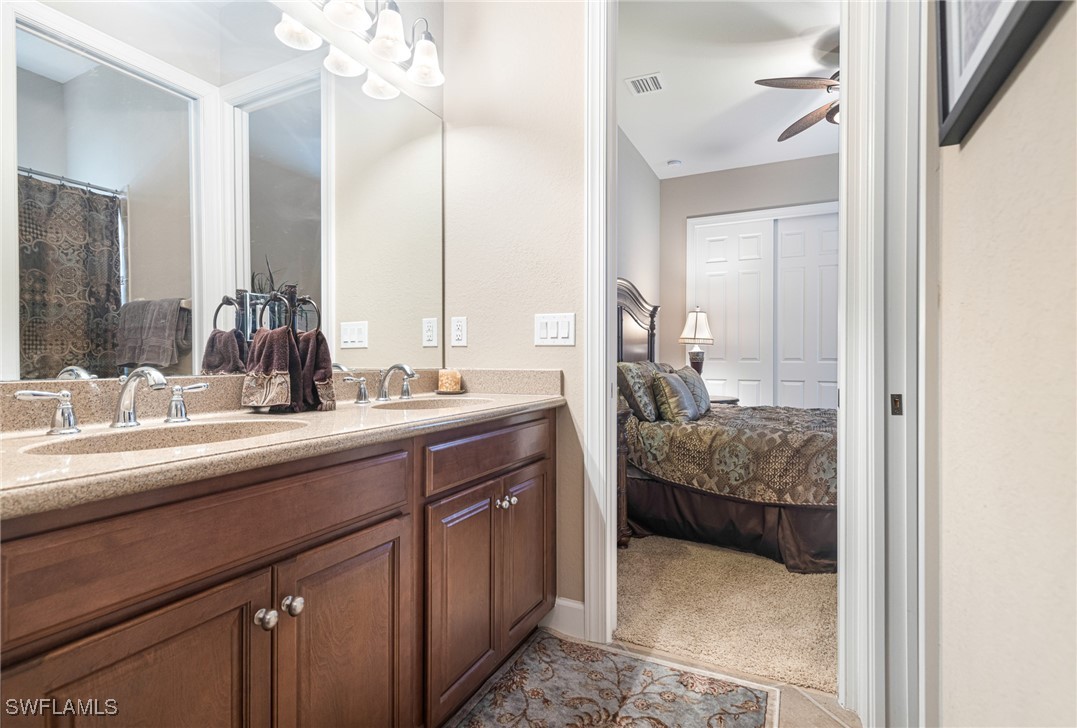 11208 Lithgow Lane Fort Myers, FL 33913 - Photo 26 of 49 a en suite bathroom with a double vanity sink and mirror