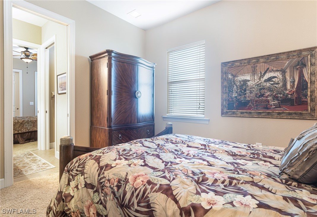 11208 Lithgow Lane Fort Myers, FL 33913 - Photo 29 of 49 a bedroom with a large bed and a chandelier