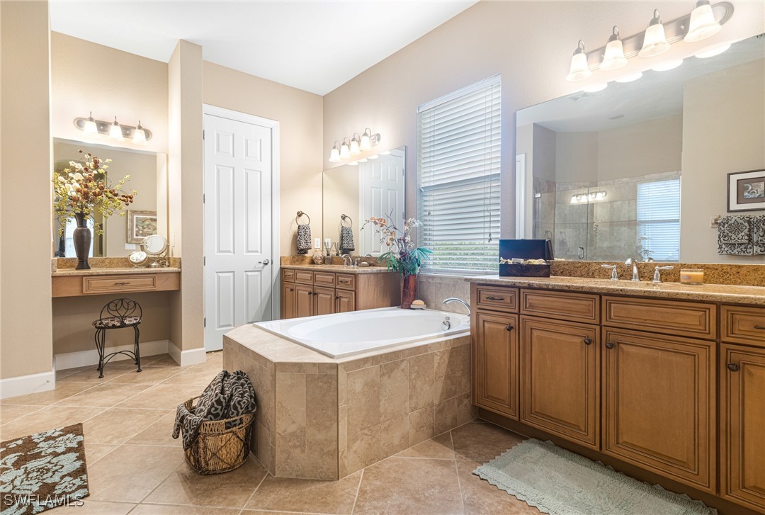 11208 Lithgow Lane Fort Myers, FL 33913 - Photo 35 of 49 a spacious bathroom with a sink a mirror and a bathtub