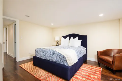a bedroom with bed and a night stand with wooden floor