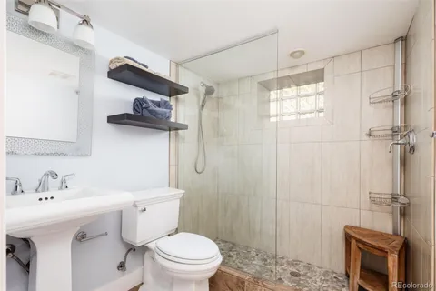 a bathroom with a sink a toilet and shower