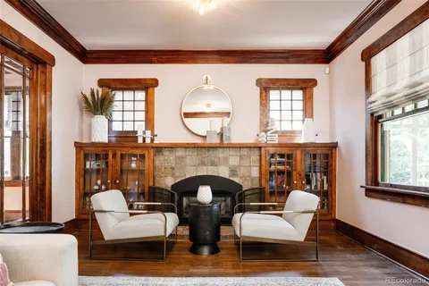 a living room with furniture a fireplace and a large window