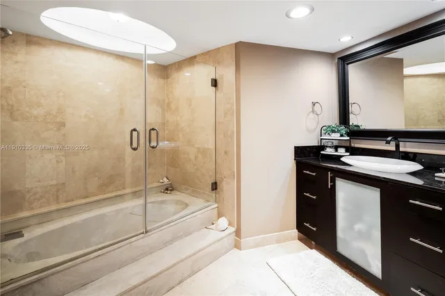 a bathroom with a granite countertop sink a mirror and a bathtub