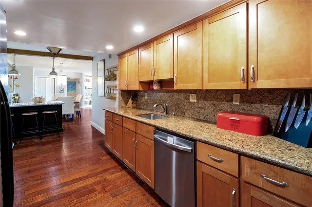 a kitchen with stainless steel appliances sink cabinets and wooden floor
