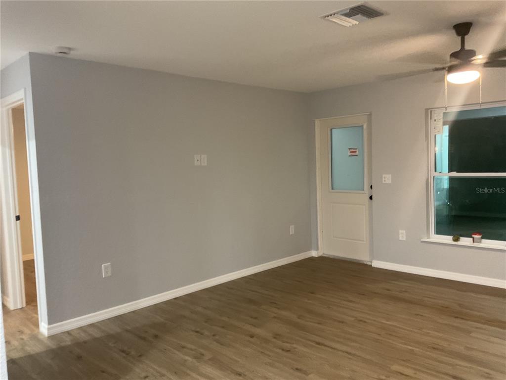 2432 Northwest 5th Street Okeechobee, FL 34972 - Photo 11 of 24 a view of an empty room with wooden floor and a window