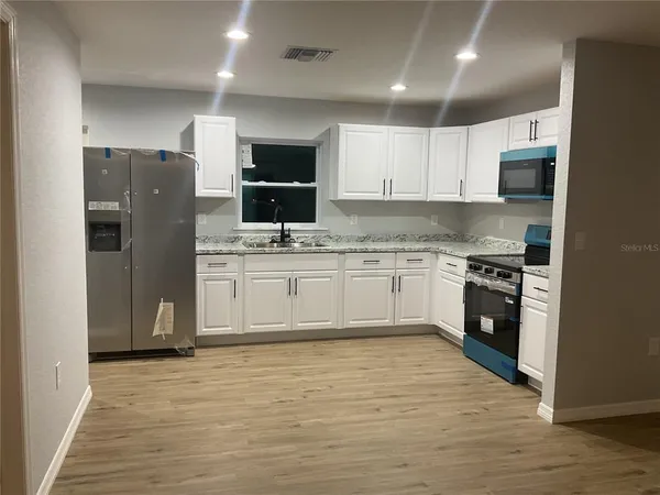 a view of a kitchen with refrigerator and microwave